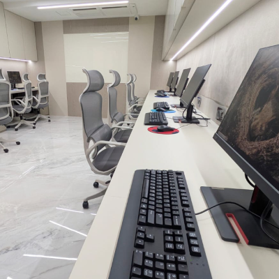 Row of workstations with monitors and ergonomic chairs at the new L7 Group office
