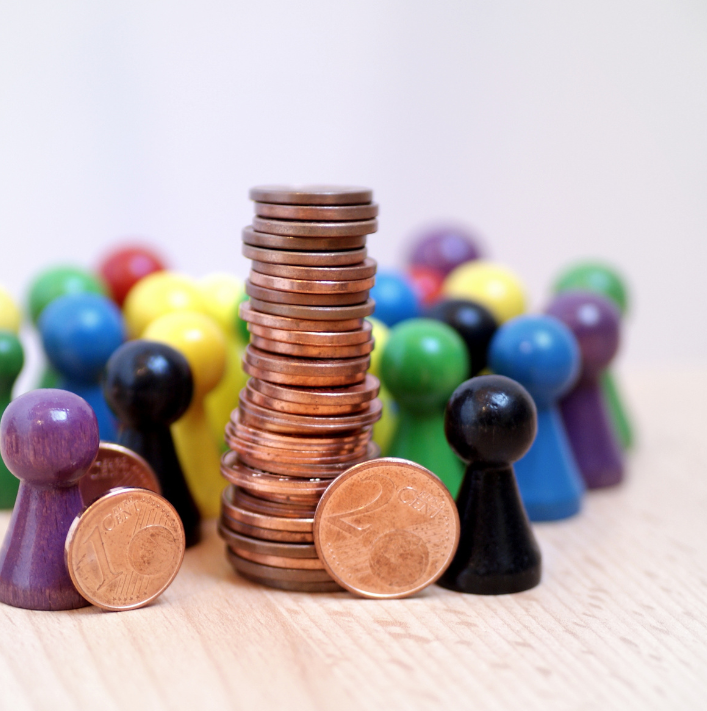 Stack of coins among coloured game pieces, representing L7 Group crowdfunding