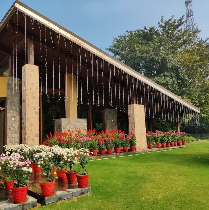 Stone-pillared pavilion with potted flowers and lawn at Chattarpur Farms (L7 Group)